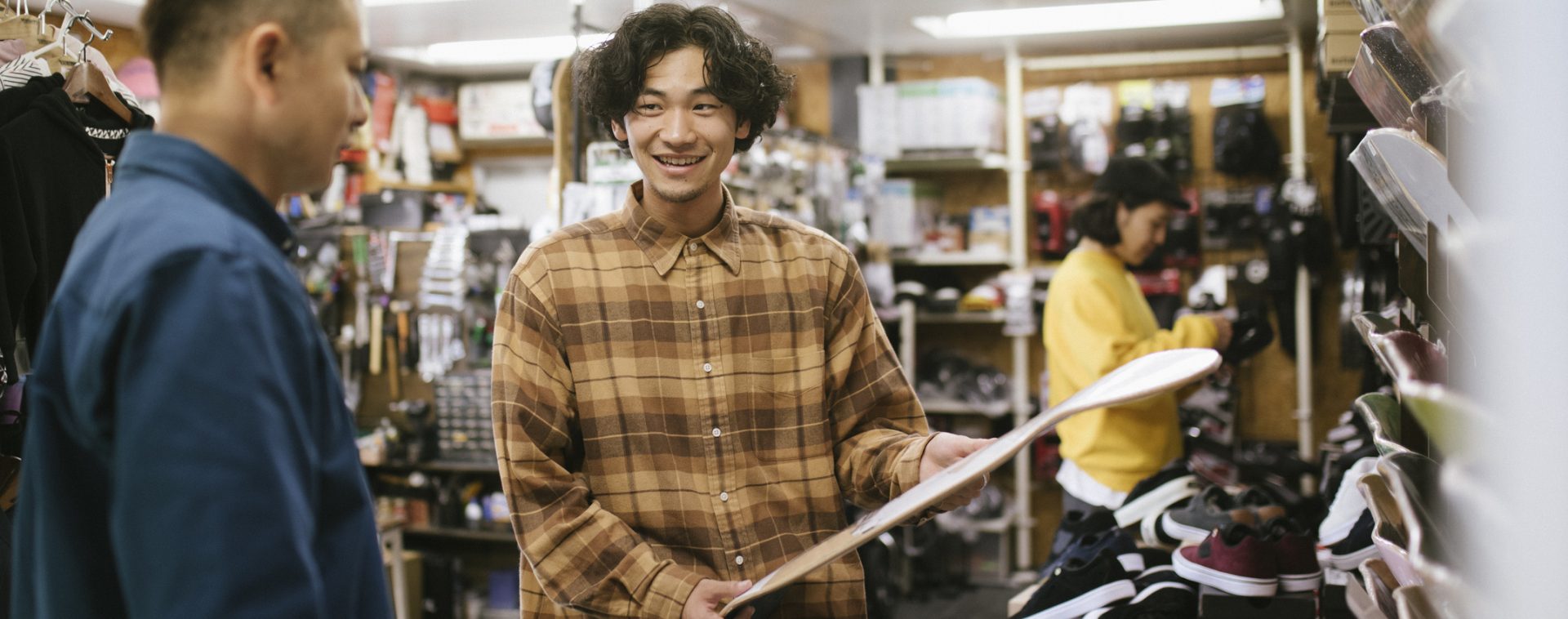 Young man choosing skateboard deck at a skateboard store.